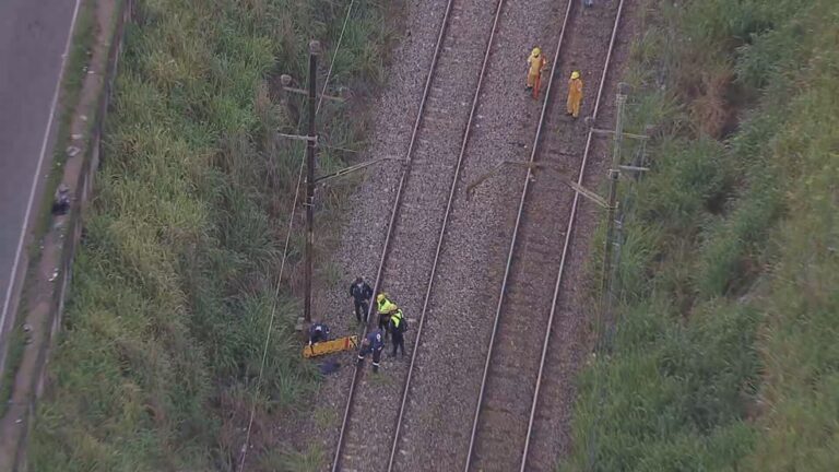 Passageiros da Supervia caminham na linha férrea após pane elétrica.